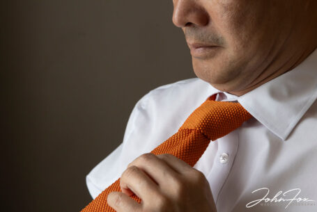 Close up of Son the groom tying his tie for his Hadley Park House wedding ceremony.