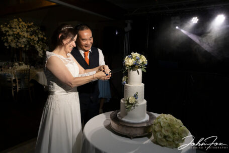 Bride and groom cutting the cake in The Mulliner Suite at Hadley Park House.
