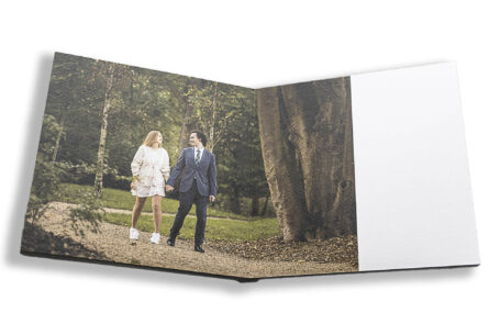 Unique personalised guest book image of Sophie and Jack walking in the grounds at Hothorpe Hall for their pre-wedding shoot.