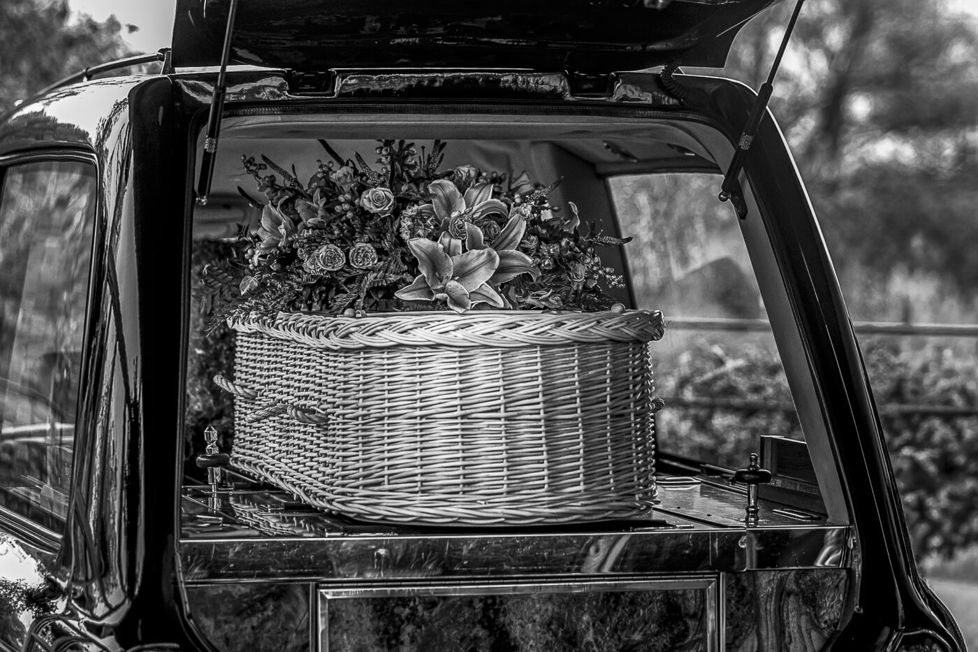 Documentary Funeral Photographer John Fox. A wicker casket inside a black hearse.