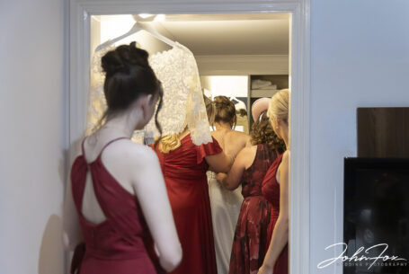 Katie's bridesmaids helping with the dress. Image by John Fox Wedding Photography.
