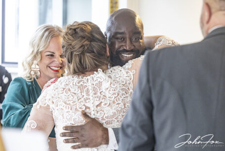 Katie the bride getting hugs from her wedding guests at her Milton Keynes' Wedding