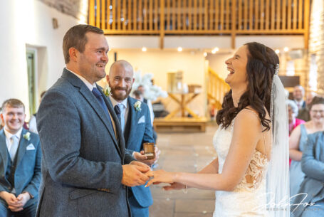 Wedding ceremony - bride and groom laughing at The Ashes Barns in Staffordshire. Photo by John Fox Wedding Photography