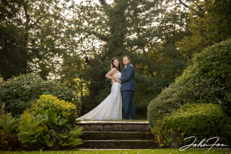 Bride and groom portrait. The couple standing at the top of stone steps at The Ashes Barns in Staffordshire