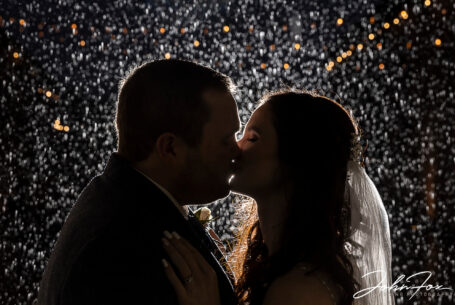 Joanne and James share a kiss in the rain. Wedding Photography at The Ashes Barns in Staffordshire