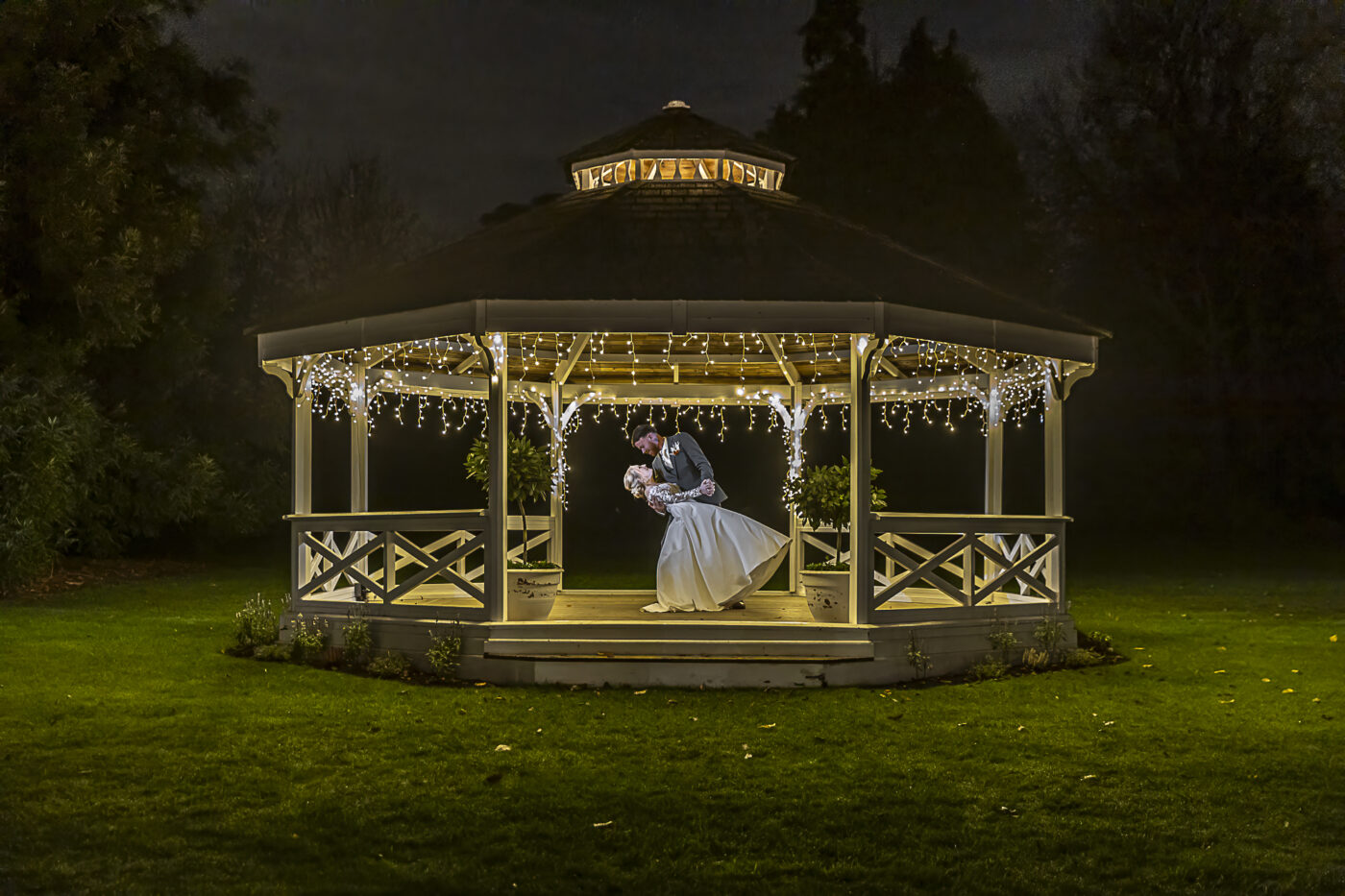 Cambridgeshire wedding: Tanya and Shane at Holmewood Hall. The newly weds dancing in lit up bandstand at night.