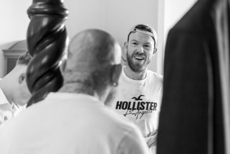 Shane sharing a joke with his groomsmen as he gets ready for his Cambridgeshire wedding at Holmewood Hall