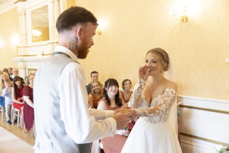 Shane putting the wedding ring on Tanya's finger as she holds back tears of joy at their Cambridgeshire wedding