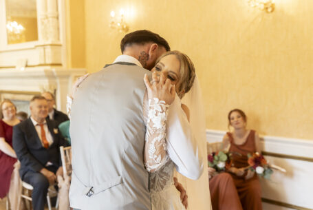 The newly-weds embrace at their wedding ceremony at Holmewood Hall, Cambridgeshire