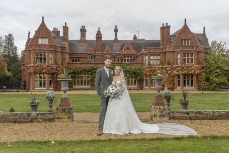 The bride and groom in front of Holmewood Hall, Cambridgeshire
