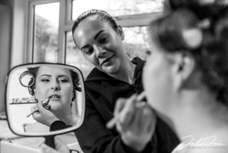 The make-up artist adding the bride's lipstick at her Northamptonshire home on the family farm