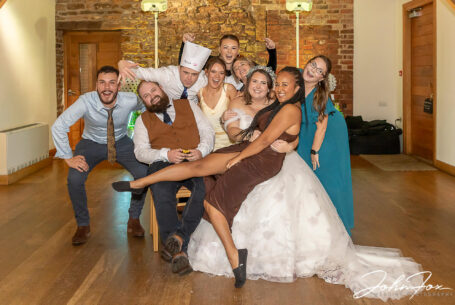 Fun photo of one of the wedding guests sitting on Abigail's lap. Northamptonshire wedding supplier, John Fox
