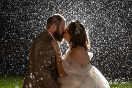 An evening kiss in the rain captured by Northamptonshire wedding supplier John Fox Wedding Photography