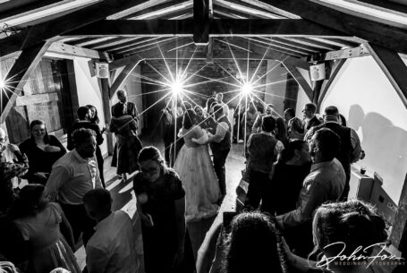 Guests on the dancefloor with bride and groom at Dodford Manor, Northamptonshire. Black and white image by John Fox