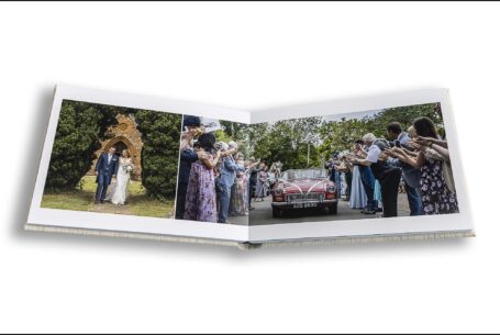 The newly-weds in a vintage red car being applauded by their wedding guests in Oxfordshire.