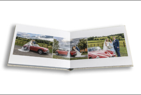 Wedding album opened at the pages showing the bride and groom and the vintage MG car.