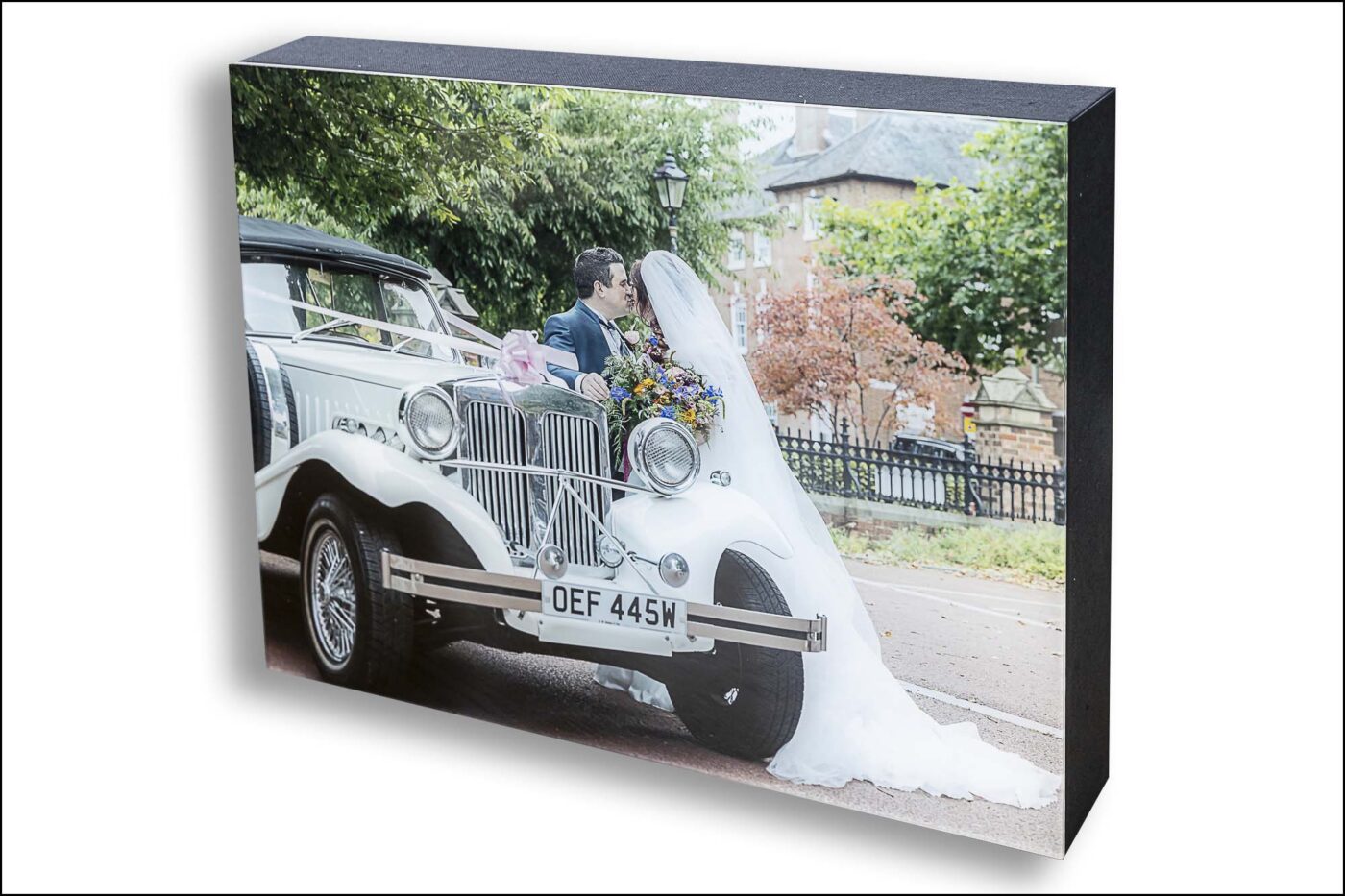 Amy and Karl’s Leicester Wedding Album with an image of the newly-weds kissing and a vintage car in the foreground. Wedding Packages in Leicestershire from John Fox Wedding Photography.