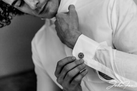 Jack fastening his cuff links as he gets ready for his Wedding Ceremony at Hothorpe Hall, Northamptonshire