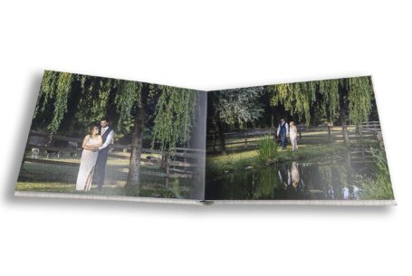 Sophia and Dimitri walking by a large pond in the Warwickshire garden. Part of the images for the bespoke wedding album by John Fox.