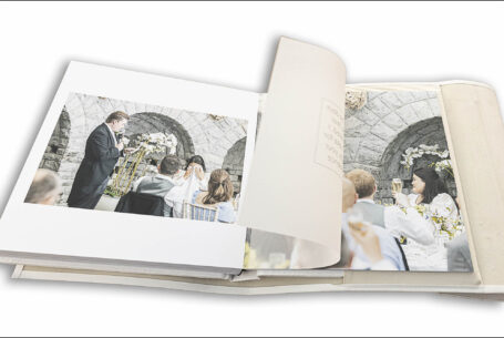 Wedding album showing images from Clare and James's speeches and translucent page with an extract of the groom's speech printed on it