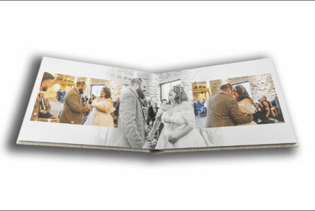 Abigail and Daniel’s Dodford Manor Wedding Album opened at pages showing the newlyweds embracing at their Northamptonshire wedding ceremony.