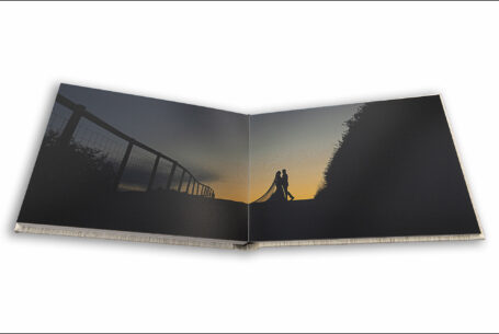 John Fox's award-winning wedding album image of the bride and groom silhouette sunset photograph at Kingscote Barn in the Cotswolds.