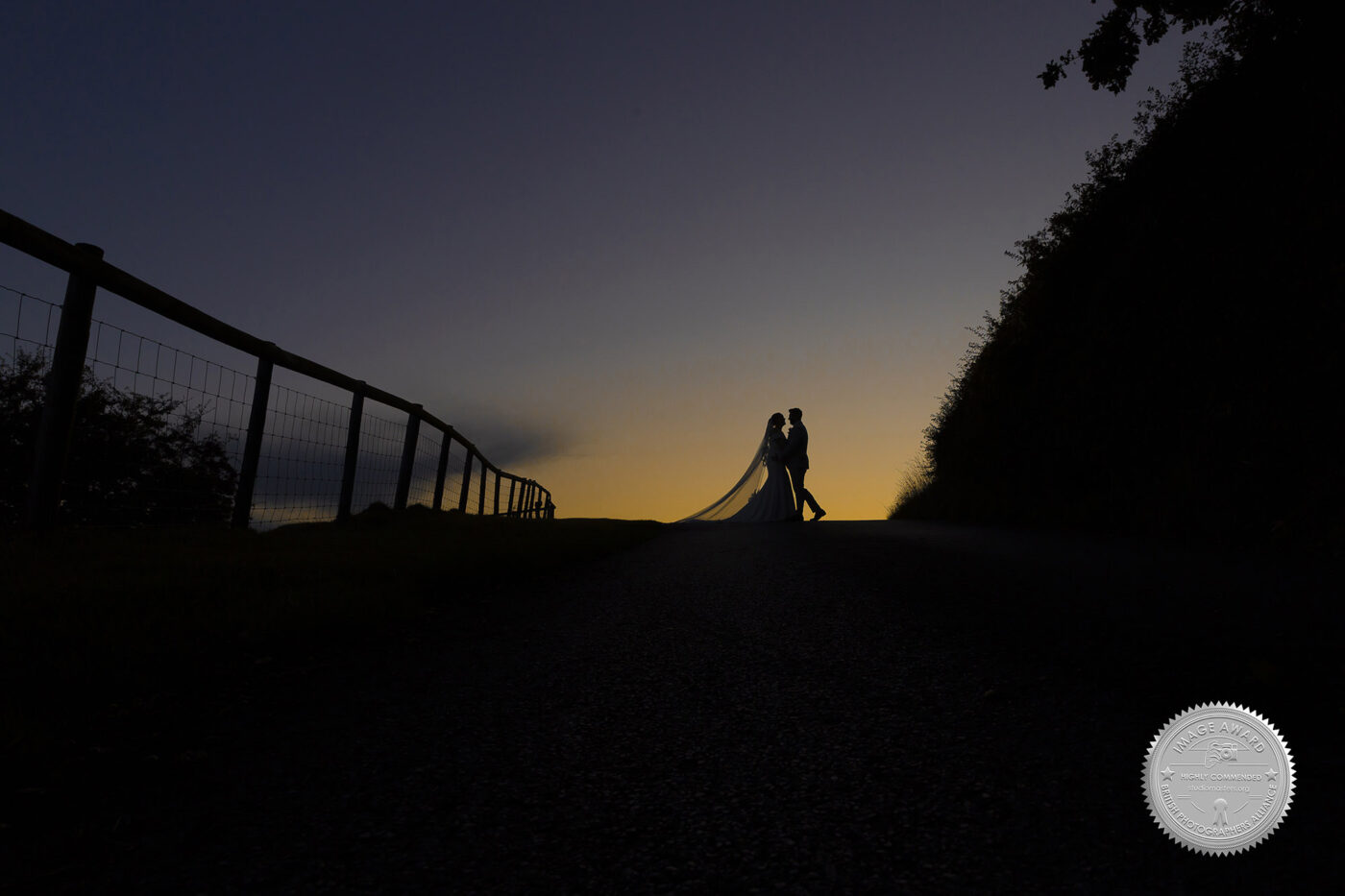 Award winning sunset silhouette of Gabrielle and William. Wedding Photographer Cotswolds - Kingscote Barn.