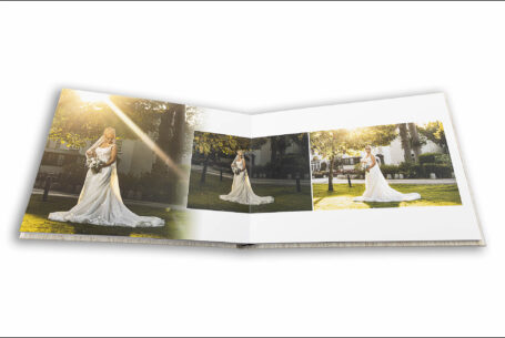 Lynn the bride in the grounds at The Five Bells pub in Stanbridge with sunlight streaming through the trees. Image by John Fox Wedding Photography.