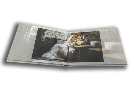 Sarah and Lewis share a quiet moment on their wedding day in a drawing room at Keele Hall in Staffordshire. Wedding album image by John Fox.