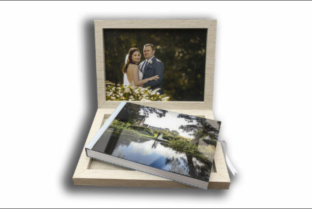 Wedding album with acrylic cover and image of the bride and groom by a lake at The Ashes Barns and the venue through the trees.