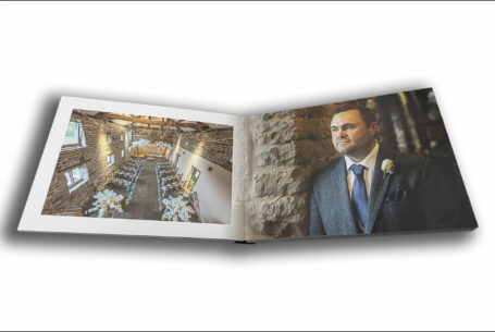 Open wedding album showing an image of the ceremony room and the groom James at The Ashes Barns in Staffordshire