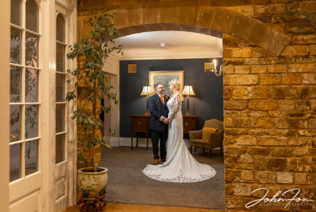 Bride and groom wedding image inside Rushton Hall in Northamptonshire. Image by John Fox Wedding Photography.