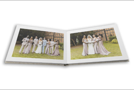 Wedding album open showing page design with images of the bridal party at The Tithe Barn, Bedfordshire