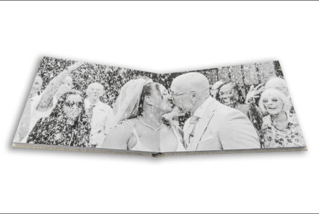 Wedding album open showing page design with a confetti image covering two pages. Hazel and Chris's wedding at The Tithe Barn.