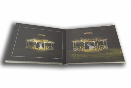 Tanya and Shane’s Holmewood Hall Wedding album opened at a page showing images of the bride and groom at night on the venue's band stand