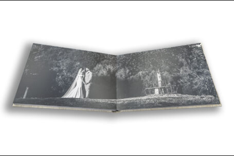 Exclusive Wedding Album image of Gabrielle and William in the grounds at Kingscote Barn in the Cotswolds set across two pages.