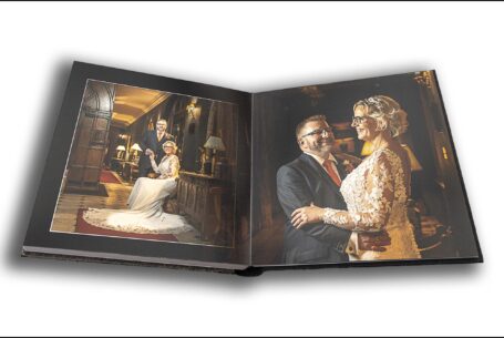 Joanne and Kevin's wedding album opened at a page showing them relaxing in a hallway at their Rushton Hall wedding. Images by John Fox Wedding Photography.