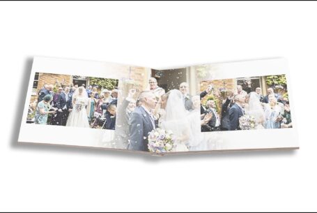 Emily and Jason’s Wedding Album opened at images of the happy couple kissing while friends and family look on. Buckinghamshire Wedding Photography by John Fox