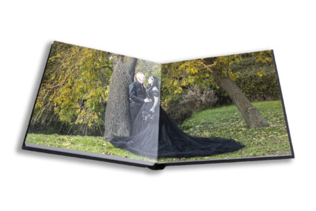 Wedding album open at an image of Louise and Jason in the grounds at Moreteyne Manor at their Bedfordshire wedding. Image by John Fox.