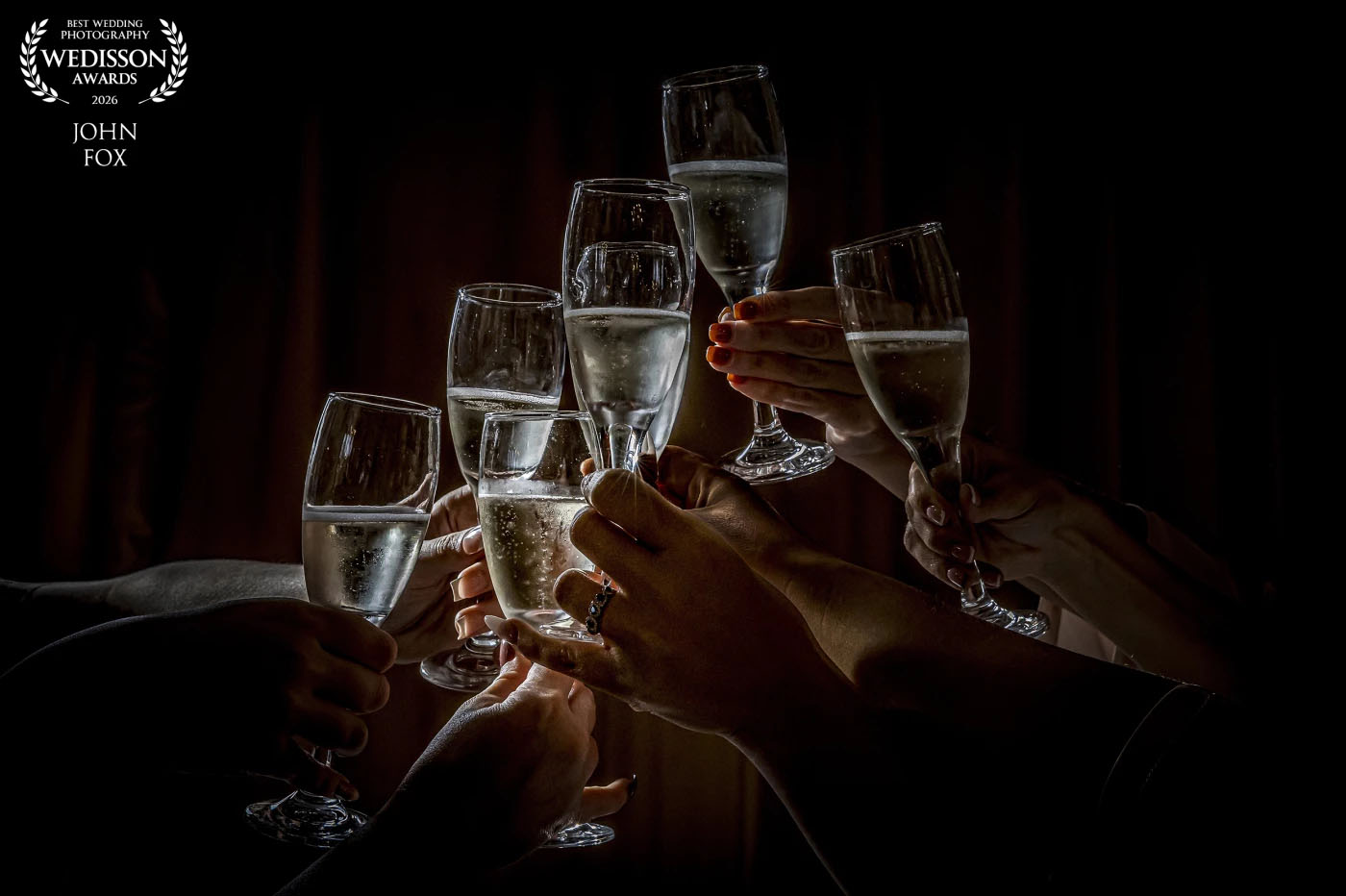 Best Wedding Photography Awards 2026 by Wedisson. International recognition for John Fox with this Fabian Perez-inspired image of glasses being raised by the bride and her bridesmaids at Holmewood Hall