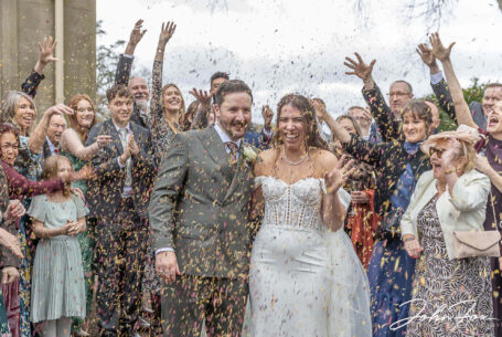 Eleanor and Oliver getting showered with confetti by their family and friends outside Kilworth House in Leicester