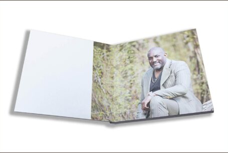 Wedding guest book with images from the pre-wedding shoot in Buckinghamshire. Image of Phil, the groom-to-be sitting on a bench.