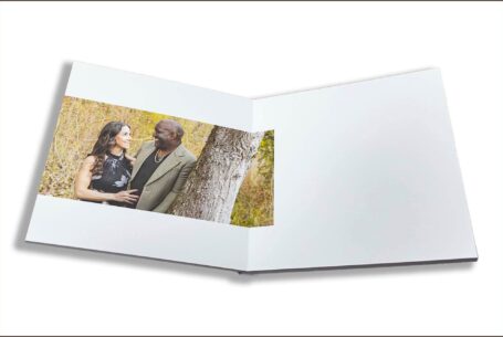 Wedding guest book with images from the pre-wedding shoot in Buckinghamshire. Image of Phil and Figan leaning against a tree while talking intimately.
