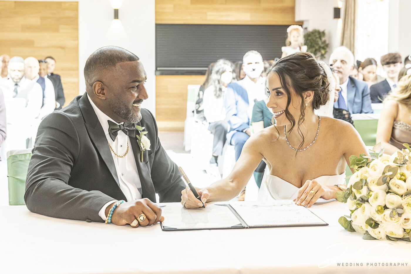 Figan and Philip signing the register at their Wedding in Milton Keynes, Buckinghamshire