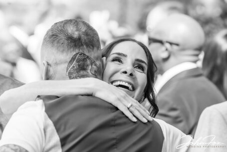 Figan laughing while hugging one of her Wedding guests at her Milton Keynes' Wedding