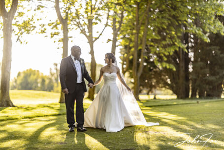 Figan and Philip walking in the grounds at Abbey Hill Golf Centre on their sunny wedding day