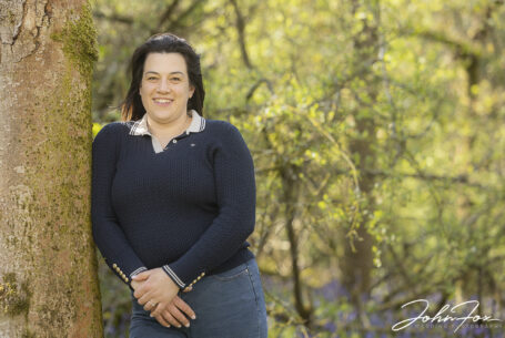 Pre-wedding shoot in Leicestershire woodland of the bride to be, Paige, leaning on a tree. Wedding Photographer covering Leicestershire, John Fox