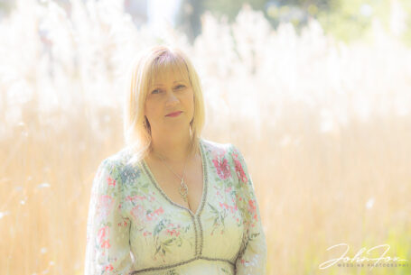 Pre-wedding shoot at Chicheley Hall. The bride with backlit reeds at the edge of a lake. Wedding Photographer in Buckinghamshire, John Fox.