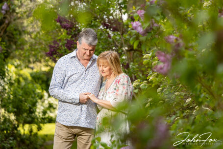 Pre-wedding shoot at Chicheley Hall. The happy couple in the gardens of the venue looking at Jayne's engagement ring. Wedding Photographer in Buckinghamshire, John Fox.