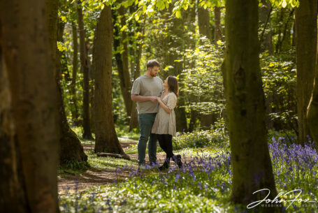 Pre-wedding shoot in Warwickshire woodland. An image of the happy couple amongst the trees and bluebells. Wedding Photographer in the West Midlands, John Fox.